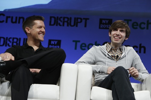 Two men sitting in armchairs at an event