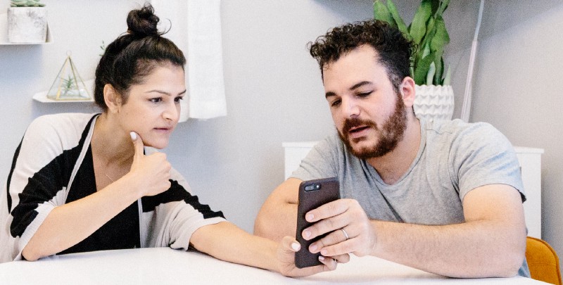 A woman and a man looking at a mobile phone